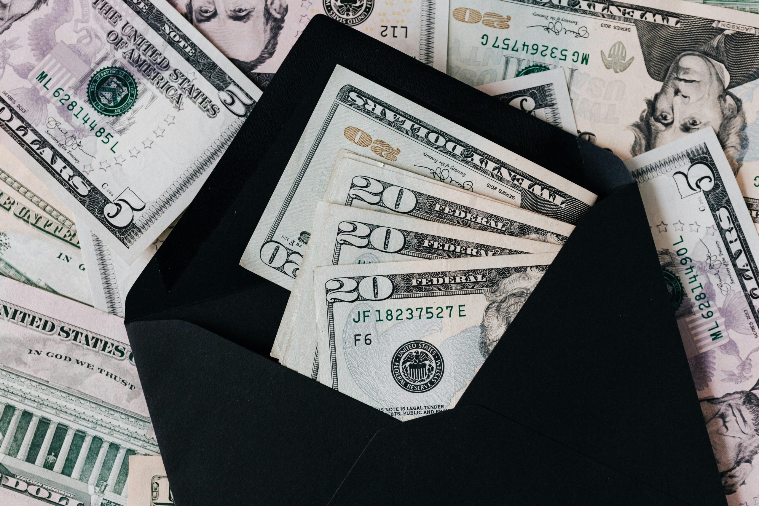 Photo by Photo By: Kaboompics.com: https://www.pexels.com/photo/set-of-black-opened-envelope-and-cash-dollars-4386370/